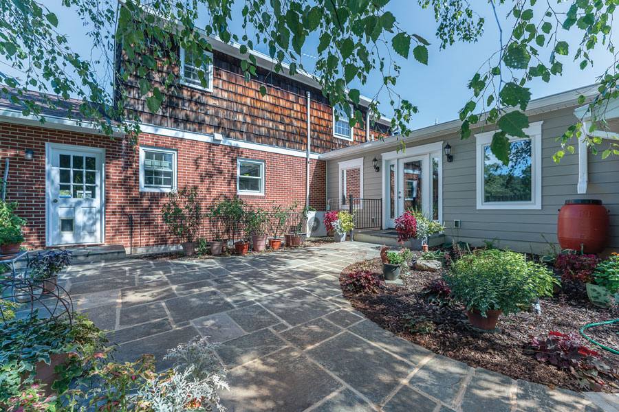 The greenstone deck connects the original home to the addition.