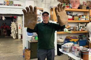 Brian Counihan shows off giant paper mache art.