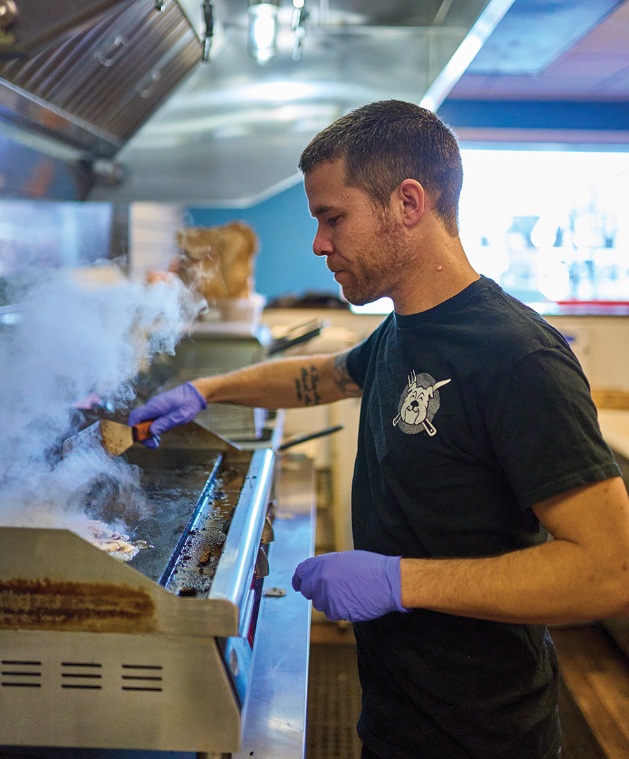 Chef-owner Brandon Stinnett tends to burgers and melts sizzling on the flattop grill.