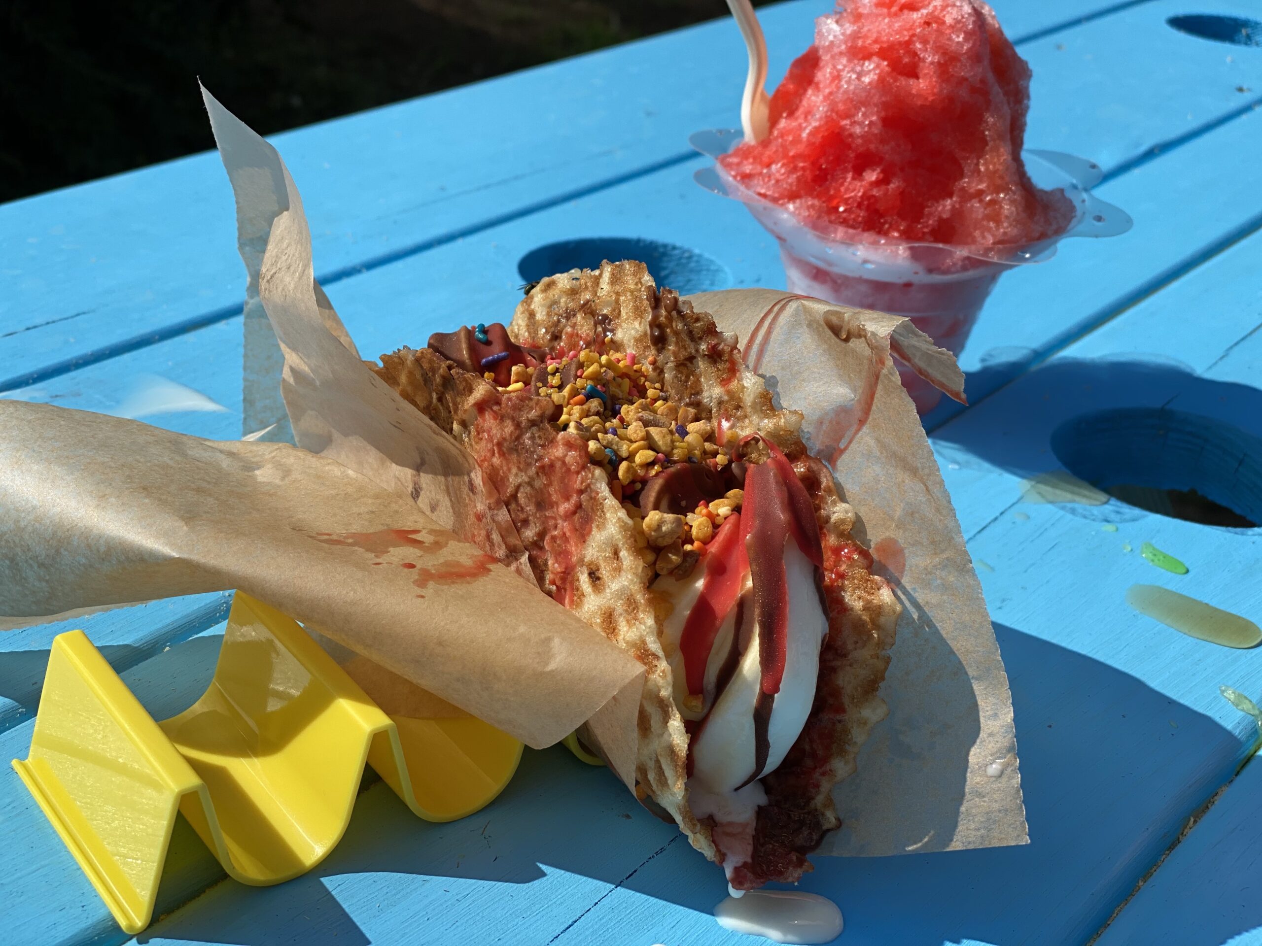 The taco, with its classic waffle cone folded like a taco, is filled with gourmet vanilla bean soft serve and Dole Whip, drizzled with chocolate and cherry magic shell sauce and sprinkled with Kona Krunch.