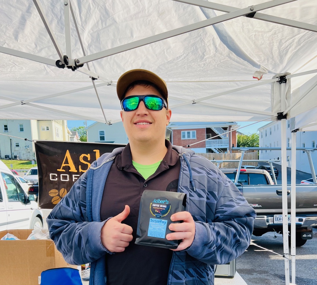 Jacob Galbraith, owner of Asher’s Coffee Beans, sells his coffee beans at Grandin Village Farmers Market.