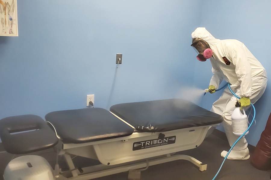 A Green Home Solutions employee disinfects an exam room.