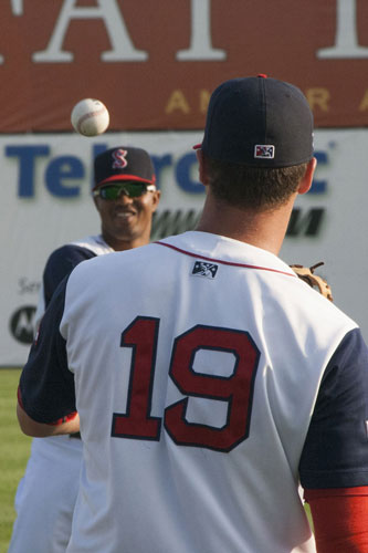 Members of the Salem Red Sox warm up for the game.