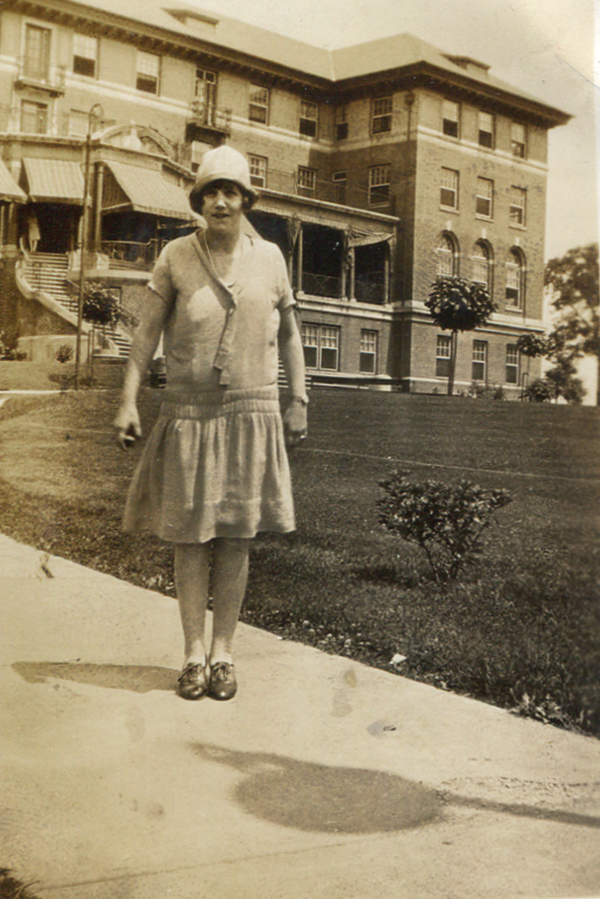 Nina Smith is seen standing along the front walk of Hill Crest Hall in this 1930s image.