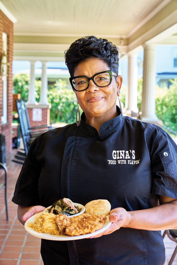 Peggy Fleming, owner of Gina's "Food with Flavor", shows off her award-winning fried chicken.