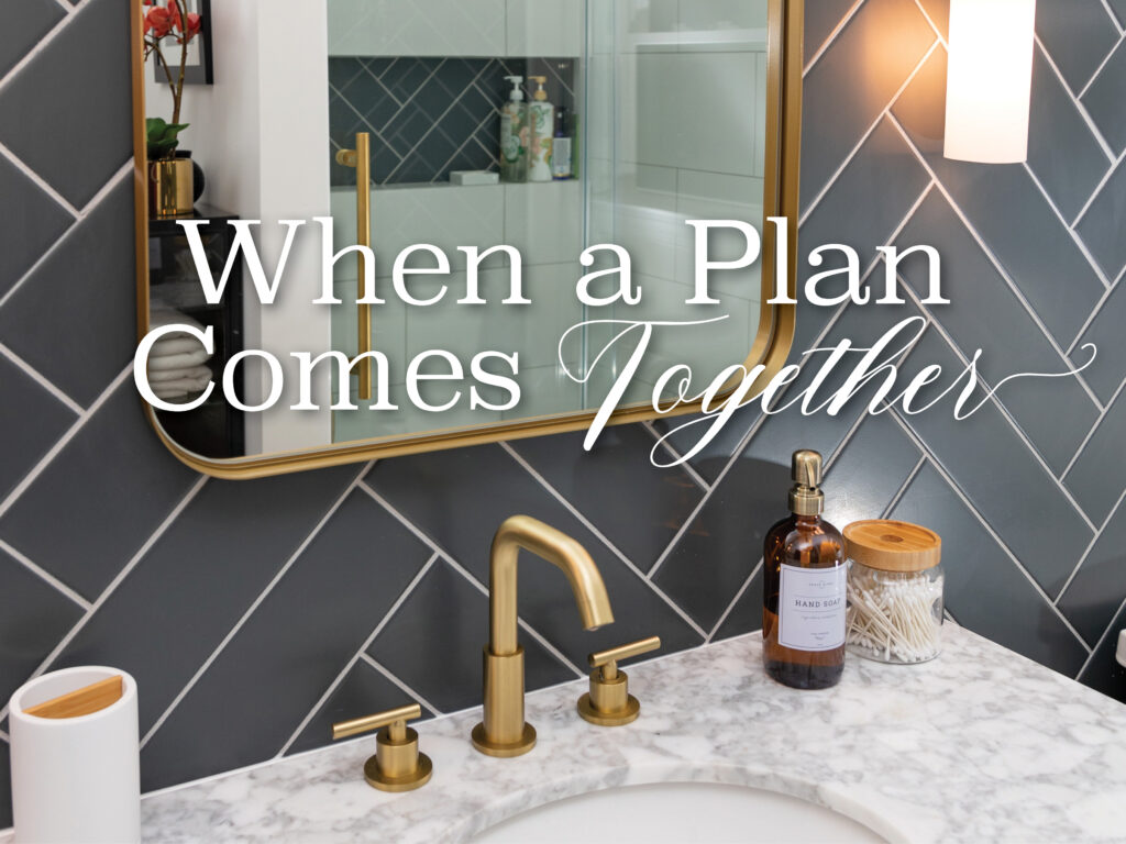 The accent wall of matte black chalkboard tile in herringbone pattern is brightened by brushed gold fixtures.