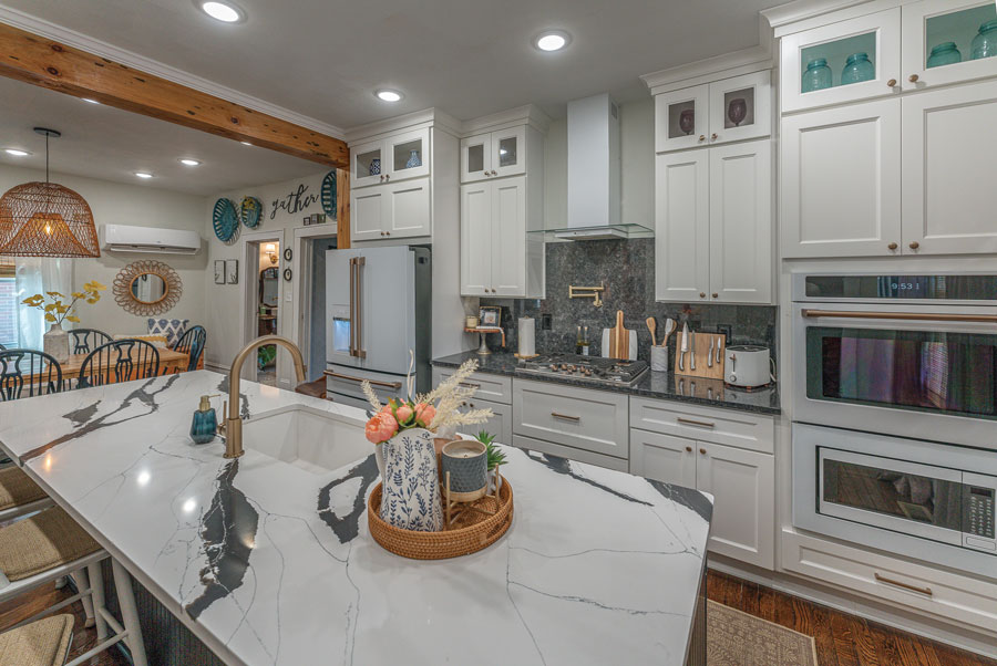 White cabinets and central island lend to a cheerful openness in the homeowners’ kitchen.