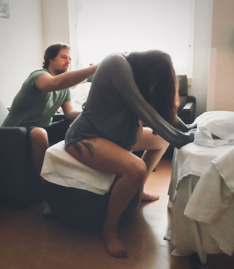 Doula Zoe Krylove captures the special moment of Molly Greene in labor with her second child as husband Andrew Greene massages her back.