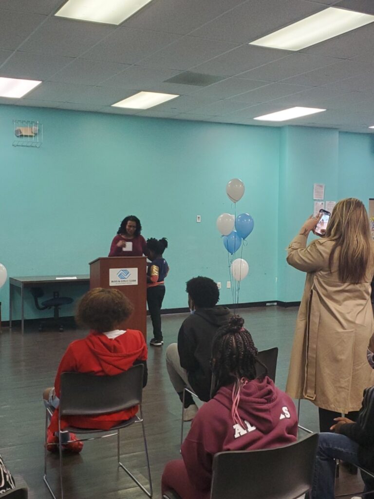 Roanoke Vice Mayor Patricia White-Boyd coaxes a shy 8-year-old winner from Salem, Markeysha Williams, up to the front to be recognized for a Black History Month Art Contest Award for a portrait of Mae Jemison. Markeysha took third place (there were three) final winners in the 15th Annual contest held by UScellular and the Boys & Girls Clubs of Southwest Virginia.