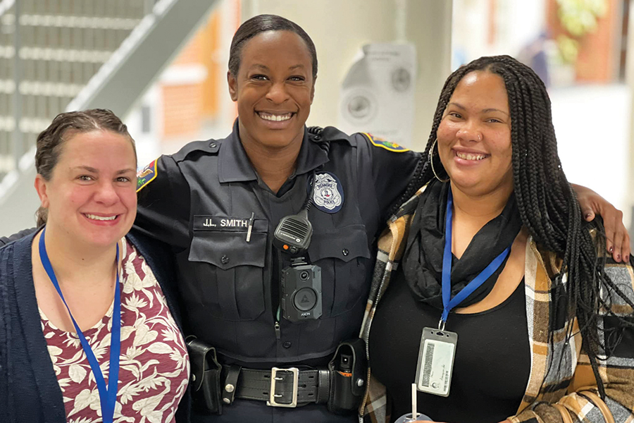 Officer J.L. Smith, center, stands with school division staffers Megan Hanks, left, and Shar Smith at Lucy Addison Middle School.