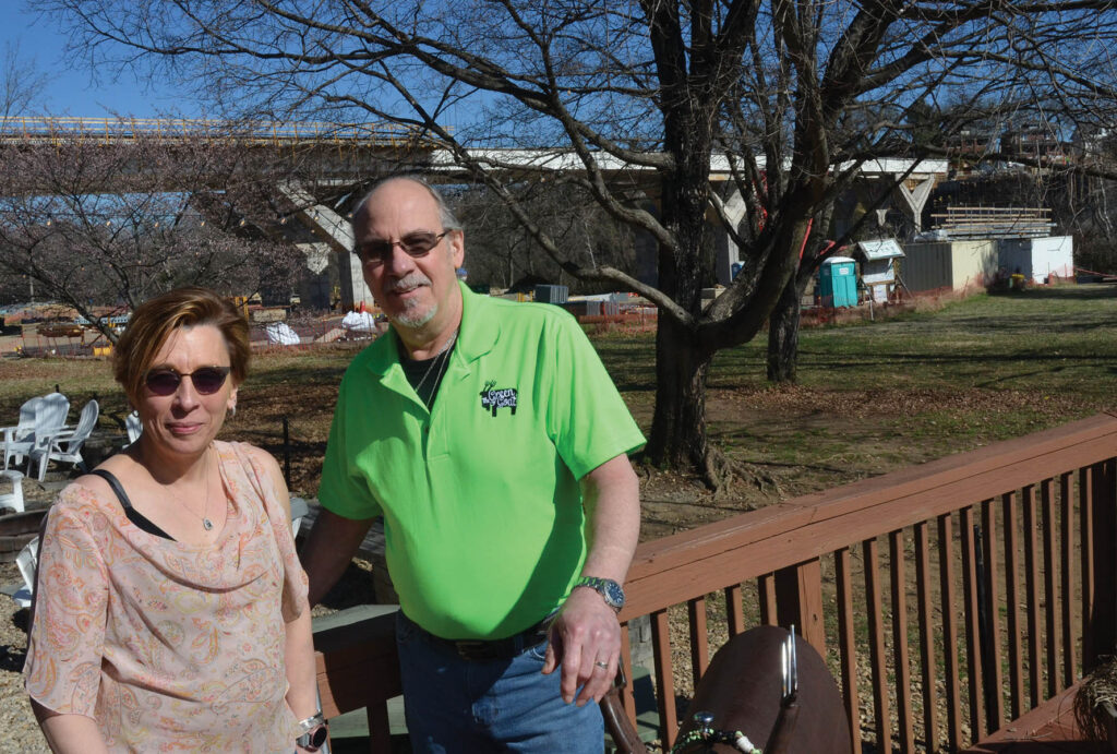 Bruce and Peggy Todaro on the deck of the Green Goat, with the Wasena Bridge behind them.