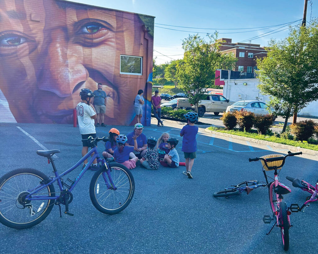 WeeWheel Roanoke began offering Learn to Ride classes last fall. Here, kids circle up at the end of a recent class in the parking lot behind Cardinal Bicycle in Grandin Village.