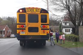 Children and mom gather meals from a Roanoke school bus.