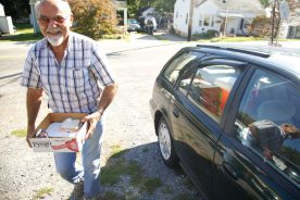 Meals on Wheels volunteer Richard Troxel prepares a delivery to Joyce Gay.