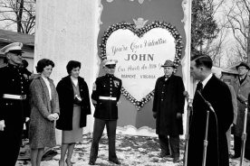 Roanoke Mayor Wick Anderson stands at the microphones as he presents Roanoke’s valentine to Annie Glenn (third from left).